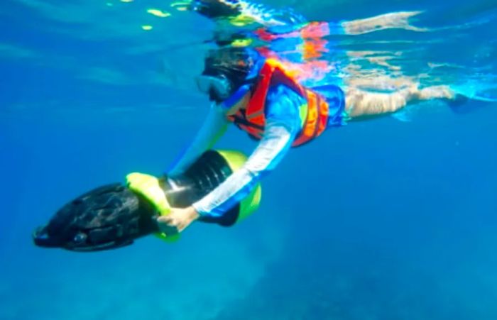 A woman enjoying power snorkeling with a Sea Doo scooter in the beautiful waters of Costa Maya.