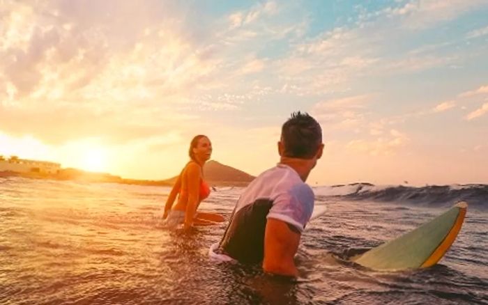 a fit couple surfing off the shores of Honolulu, Hawaii