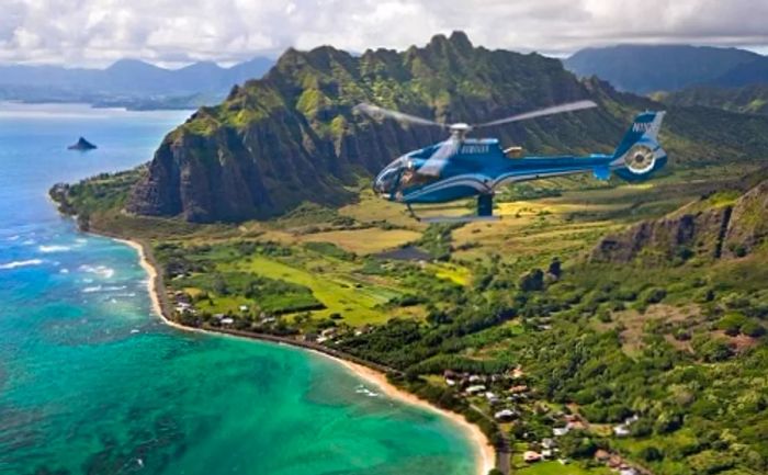 a blue helicopter soaring over the island of Oahu, departing from Honolulu