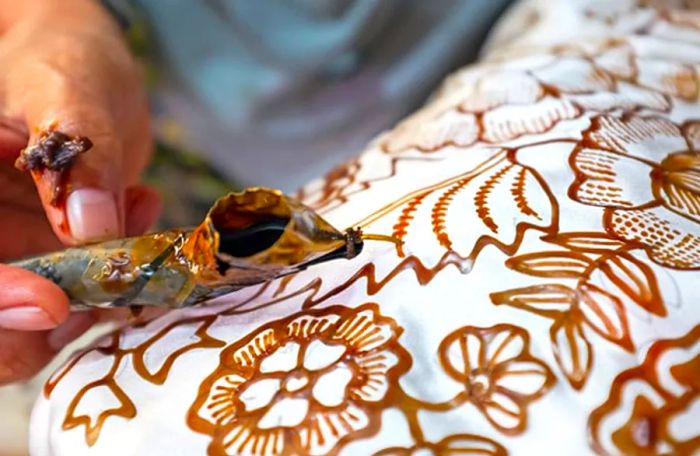 an artist crafting batiks from a plain white cloth