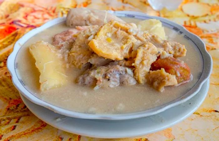 a bowl of Rondón from Limon featuring coconut, carrots, yams, potatoes, and peppers