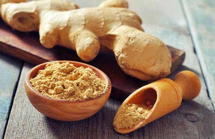 a bowl containing ginger root alongside ginger powder