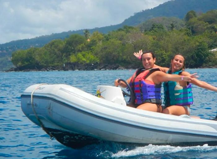 two women steering a boat to St. George’s lagoon in Grenada