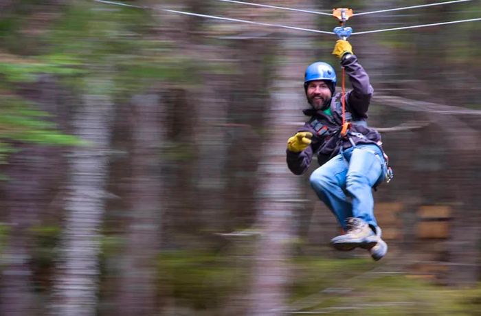 a man ziplining through the stunning scenery of Grizzly Falls