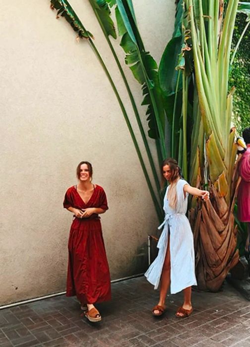 Tess & Sarah dance joyfully in the town surrounded by greenery