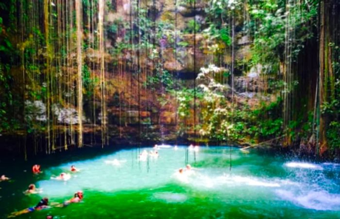 groups of people enjoying a swim in the underground pool located near the pyramid and temples of Chichen Itza