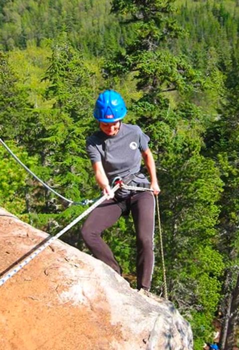 a woman rock climbing on Klondike Rock secured by a rope