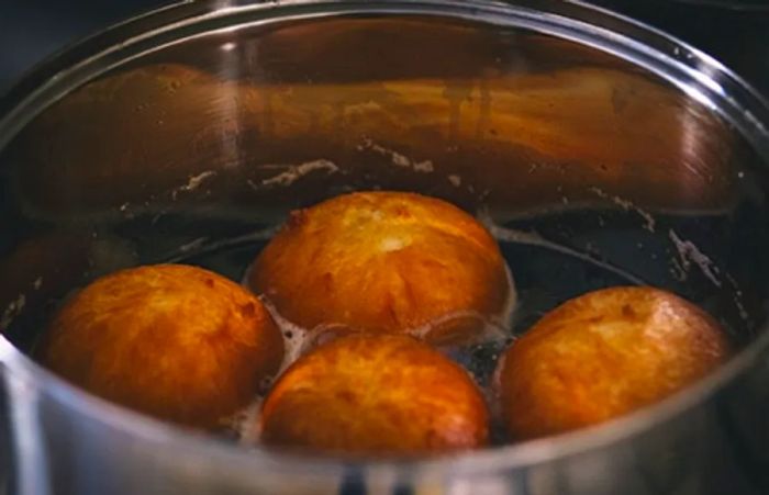 four Johnny Cakes frying in a pot in Tortola