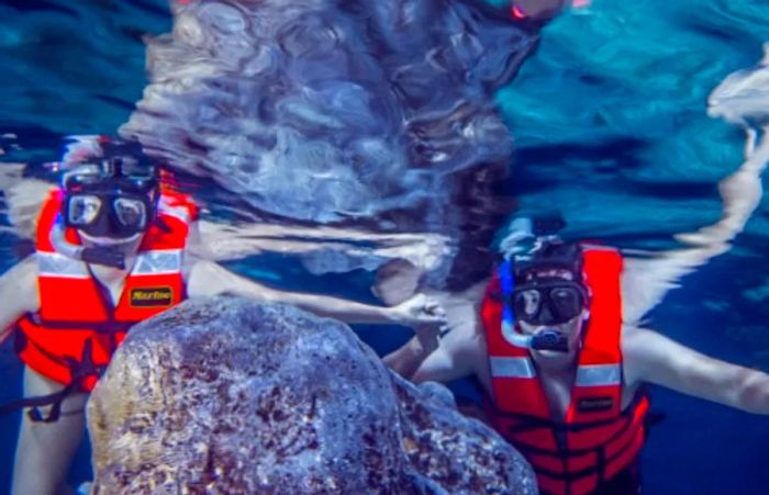 a man and woman snorkeling in a sacred Mayan cenote near Progreso