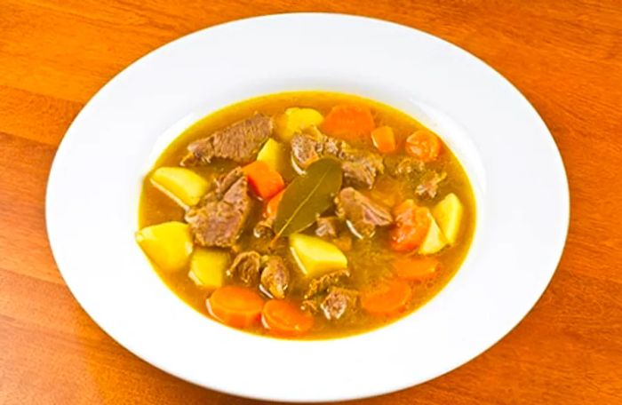 Goat water from St. Kitts, featuring tender goat meat, vegetables, and potatoes