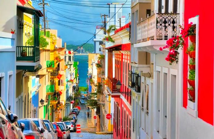 a row of vibrant houses lining a street in Old San Juan that leads directly to the ocean