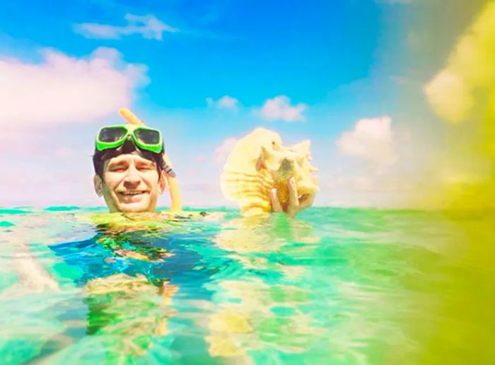 Randy displaying a conch shell while in the water