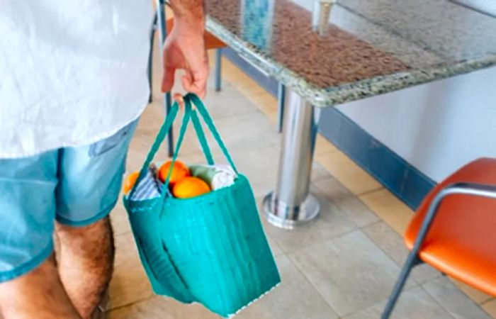 Drea’s husband carrying a turquoise bag filled with oranges