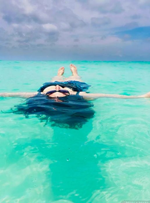 Beth leisurely floating in the inviting waters of Eagle Beach