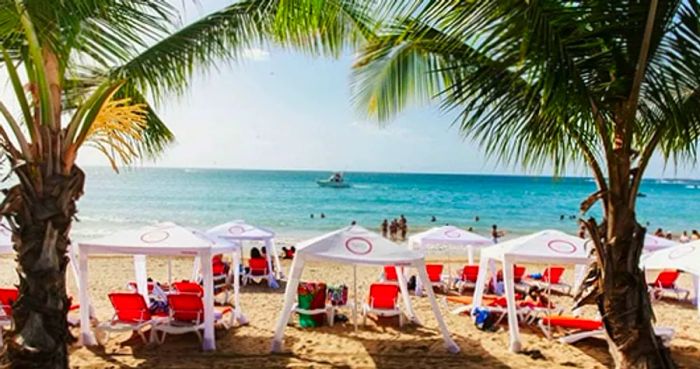 beach tents and chairs scattered around Vivo Beach Club in San Juan as visitors enjoy the ocean