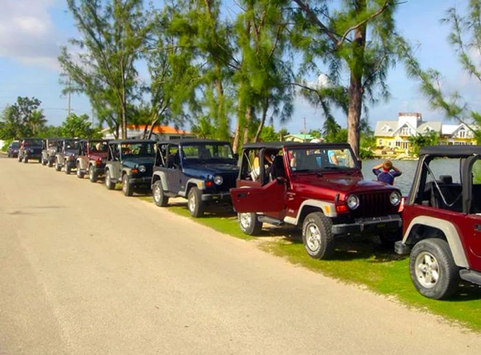 several 4x4 jeeps lined up on a street in Grand Cayman