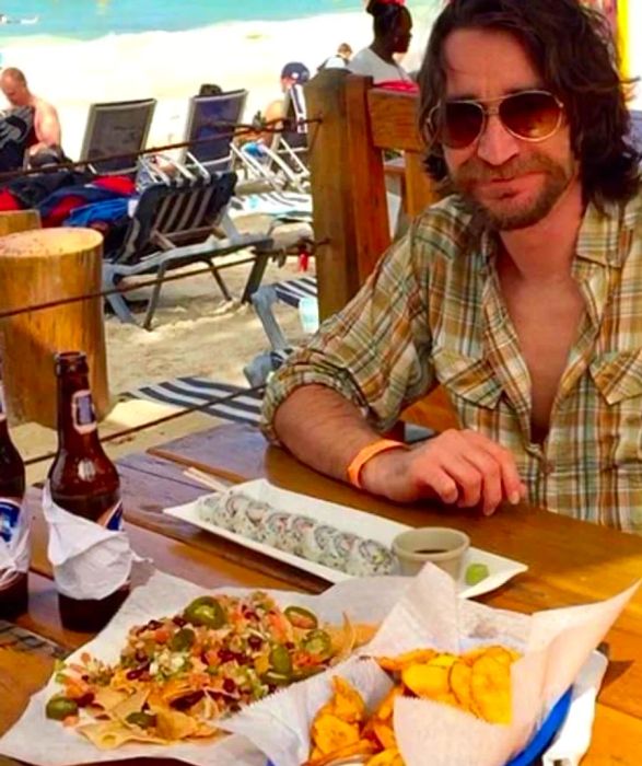 Randy enjoying sushi, chips, and nachos at West End Beach, Roatan, Honduras