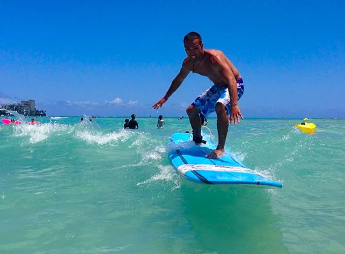 man surfing on a blue board off the coast of San Juan, Puerto Rico