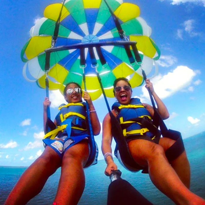 two women capturing a selfie while enjoying a parasailing experience off the shores of St. Thomas