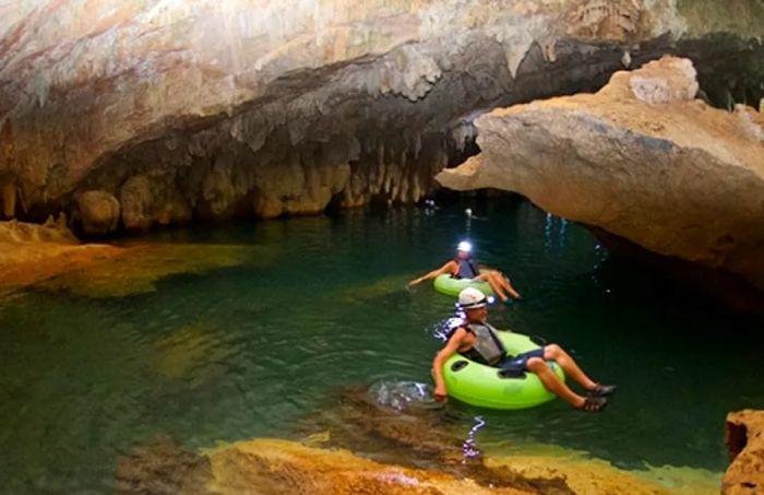 two individuals tubing in ancient Mayan ceremonial caves, Crystal Cave