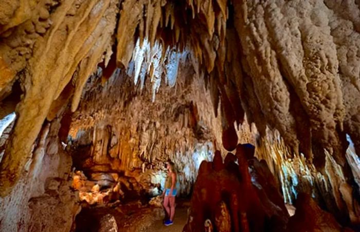 woman standing amidst the stunning crystal cave in Grand Cayman