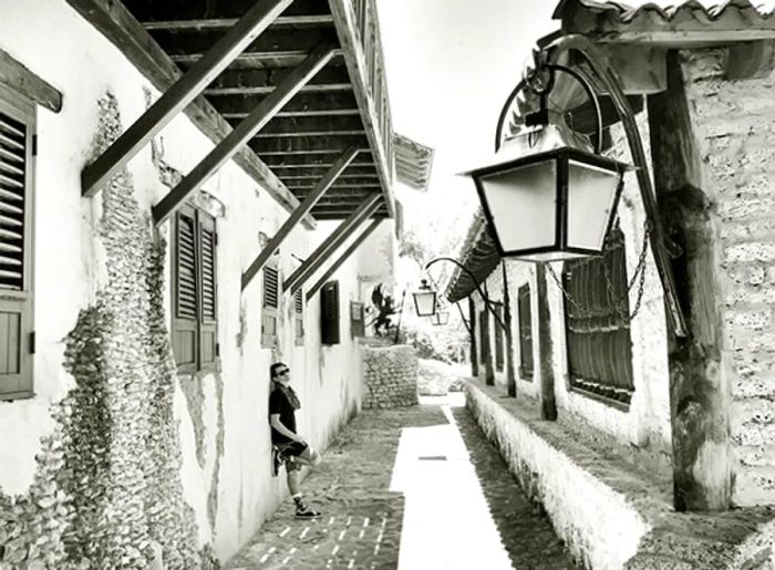 A monochrome photograph of Randy casually leaning against a building in La Romana