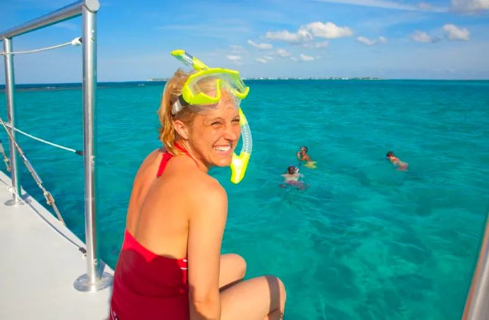 A woman giggles as she sits on a boat, preparing to snorkel in St. Maarten