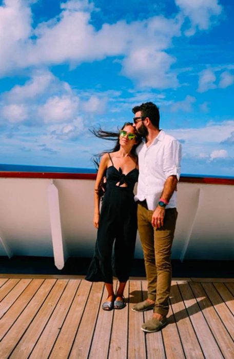 Drea’s husband gently kisses her forehead on the ship’s deck