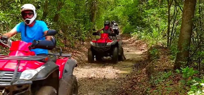 group of people riding red atvs on dirt roads in san juan