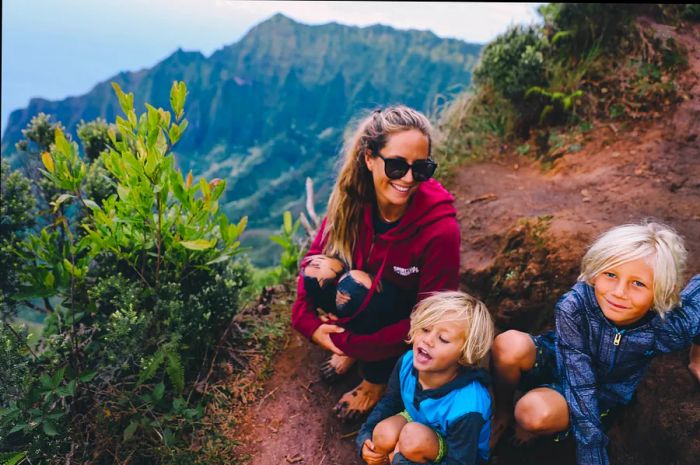 Andy and the kids sitting on a muddy trail