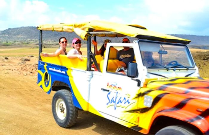 a tourist enjoying a safari tour of Aruba's north coast from the back of a jeep