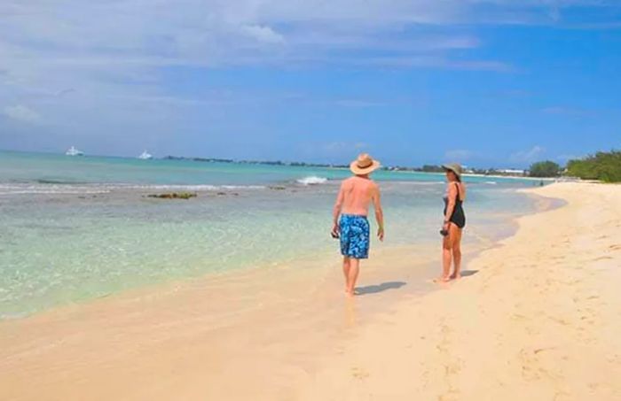 a couple strolling along Seven Mile Beach in Grand Cayman