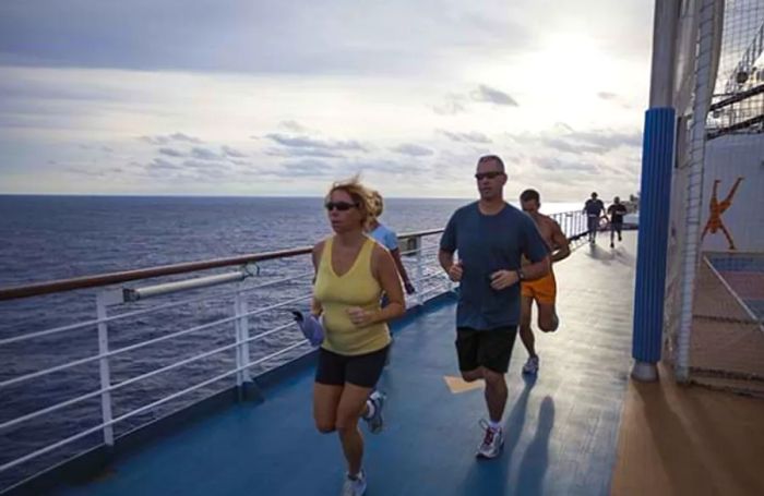 a group of individuals jogging on the track of a Dinogo cruise ship