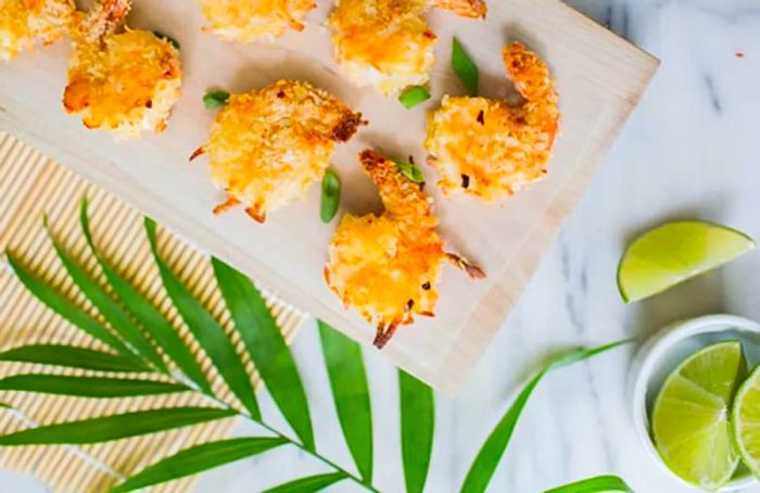 Breaded coconut shrimp arranged on a baking pan