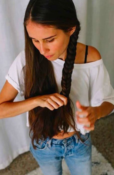 Close-up shot of Drea braiding one side of her hair