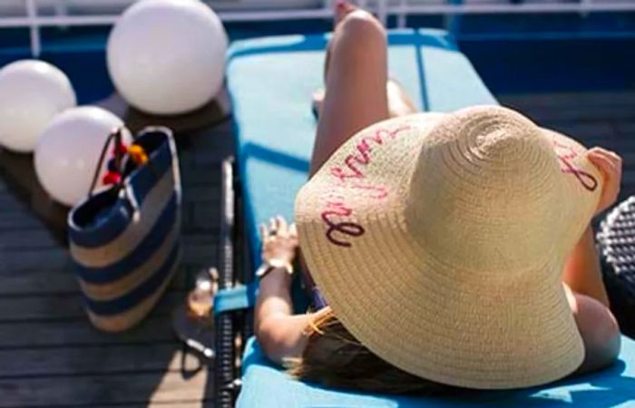 Aerial shot of Caroline relaxing in a lounge chair, sporting a sun hat