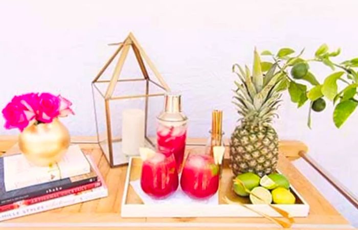 Sea Breeze cocktail, fresh fruits, and vibrant flowers set on a wooden table