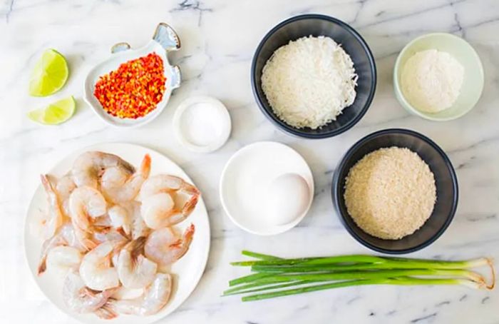 Overhead view of coconut shrimp ingredients arranged on a kitchen counter