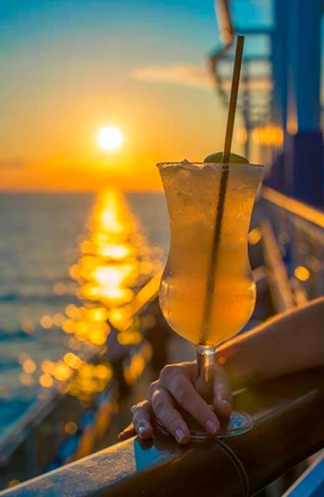 a cocktail against a stunning sunset backdrop