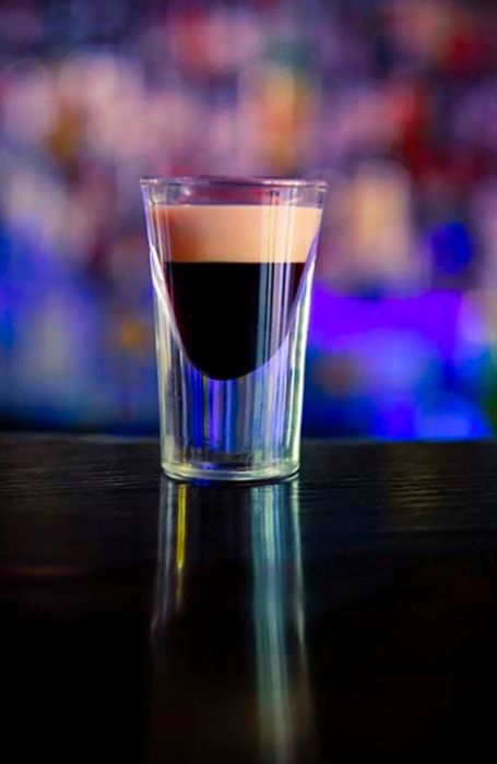 Shot glass featuring Kahlua coffee liqueur with a layer of Irish cream on top.