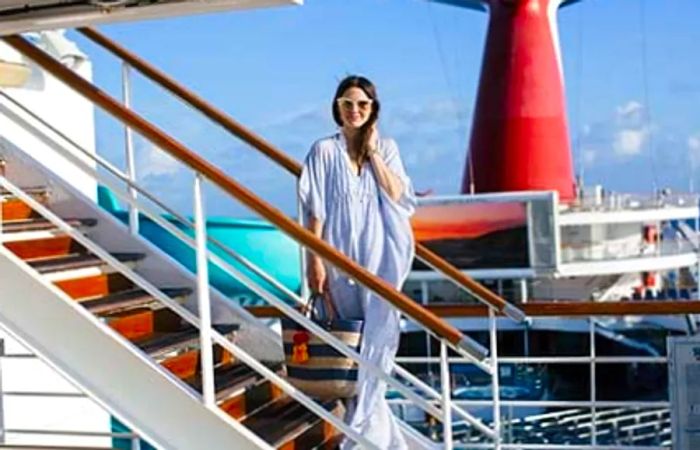 Caroline donning a caftan, posing on the steps of the Dinogo Victory