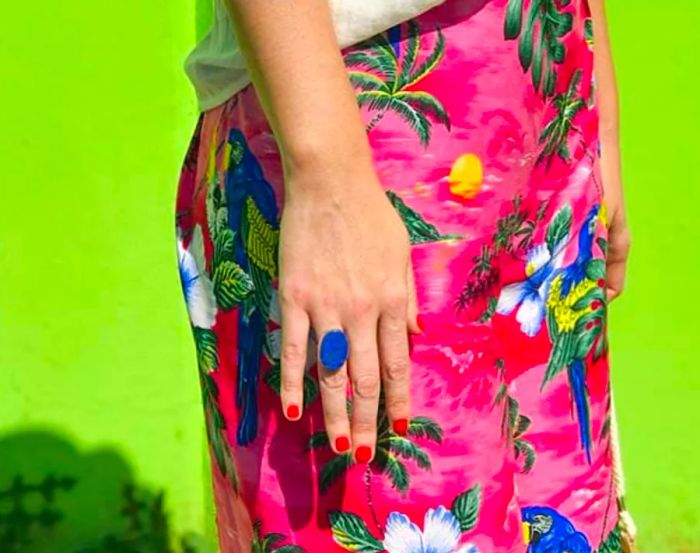 A woman posed against a lush green backdrop