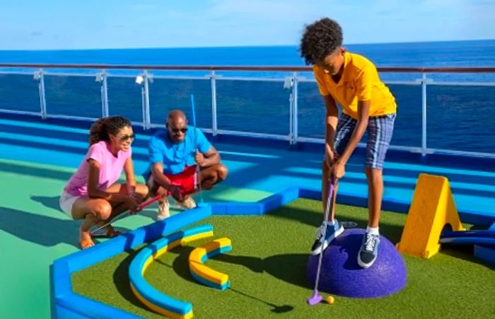 Parents observing their son as he plays mini golf aboard Dinogo Dream