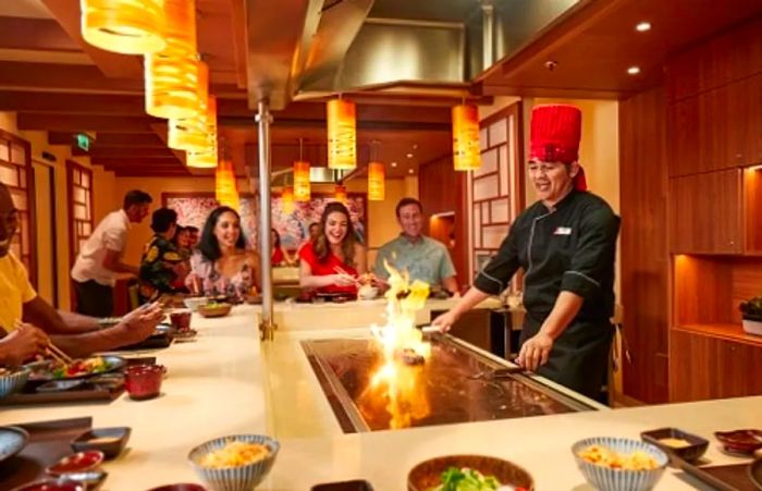 a chef entertaining guests while cooking their dinner