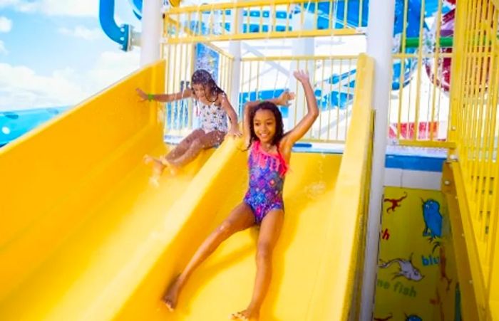 Two girls sliding down a water slide at the waterworks on Dinogo Dream