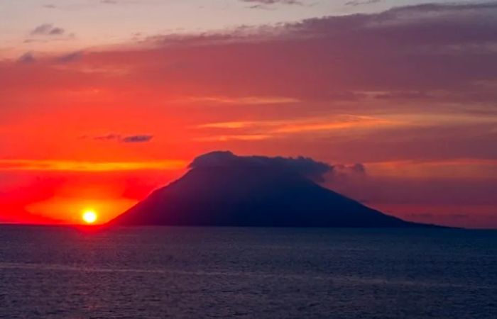 a volcano in Hawaii silhouetted against the setting sun