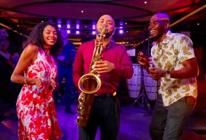 a couple enjoying a lively moment with a saxophone player at Havana Bar