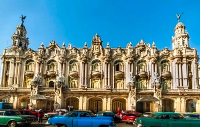 vintage cars passing by El Gran Teatro de La Habana