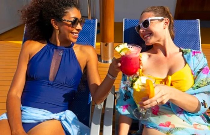 Two friends enjoying drinks together on the cruise deck