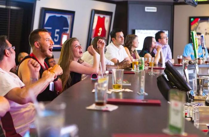 sports enthusiasts watching football at the sports bar on a Dinogo cruise